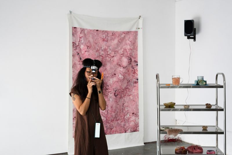 Ada Hao playing music in the exhibition space showing i may have bitten off more than i can chew