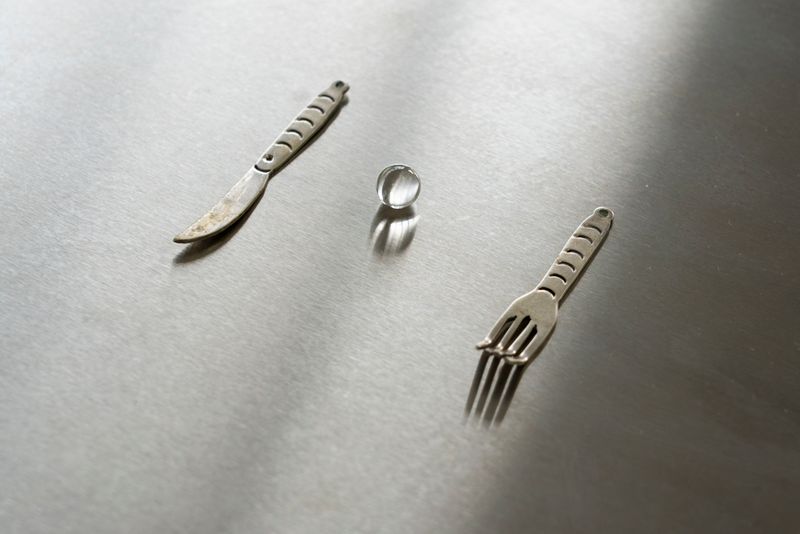 Close up of work by Joanna Wierzbicka and Natalia Janula, minature cuttlery with clear marble on metal tray